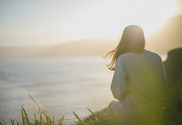 Girl watching the sunset at the beach